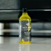 CITRINE Traffic Film Remover, butelka 750 ml stojąca na podłodze na tle rozmytego samochodu