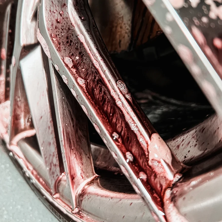 Zbliżenie na felgę pokrytą czerwoną pianą po zastosowaniu AMETHYST Rim Cleaner