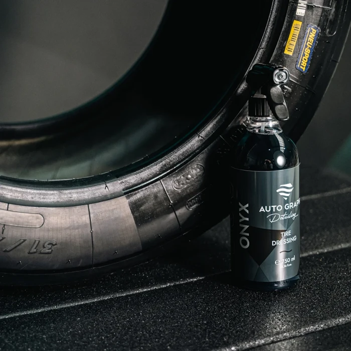 Butelka ONYX Tire Dressing oparta o oponę widoczną z boku, turkusowy akcent w tle