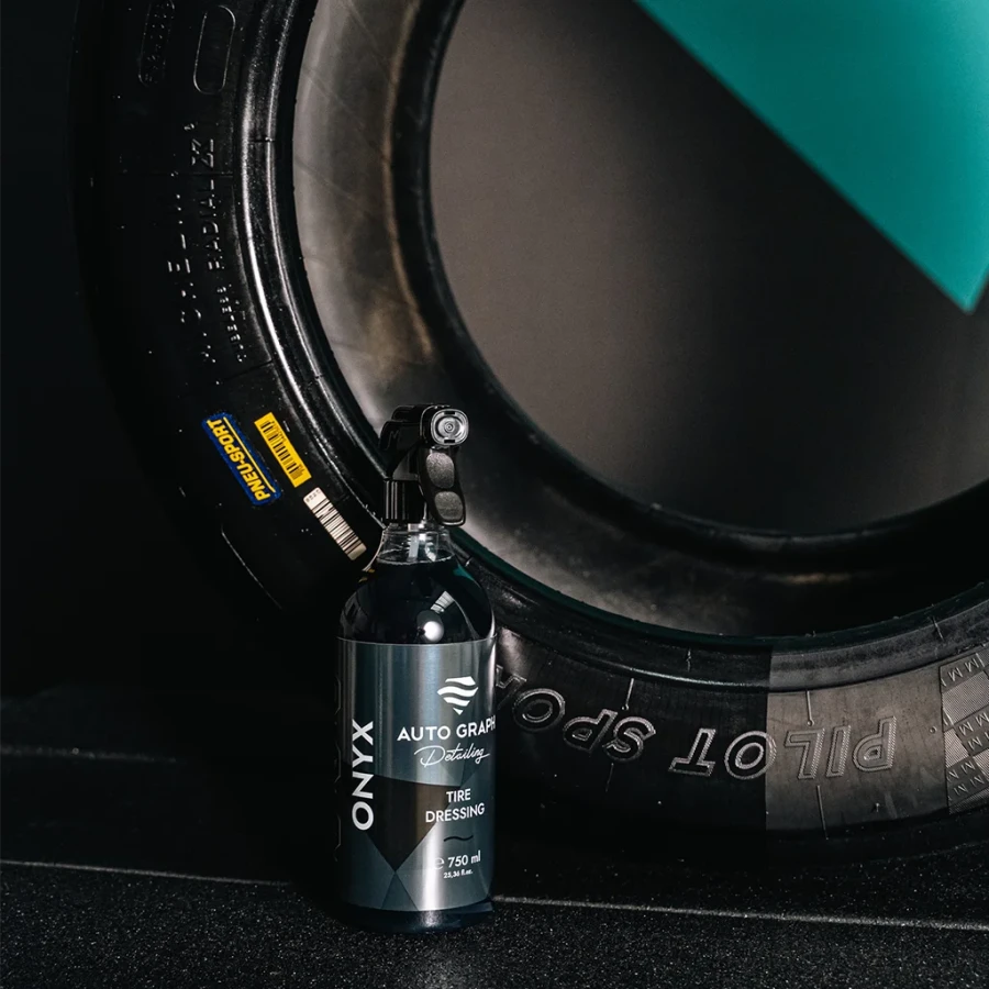 Butelka ONYX Tire Dressing przy oponie z napisem Pilot Sport, turkusowe tło