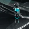 Butelka LAZURITE Water Spot Remover stoi na masce mokrego samochodu przy wycieraczce